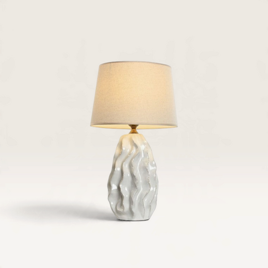 Vintage Industrial Gabun table lamp featuring a white wavy porcelain base and a neutral fabric drum shade.
