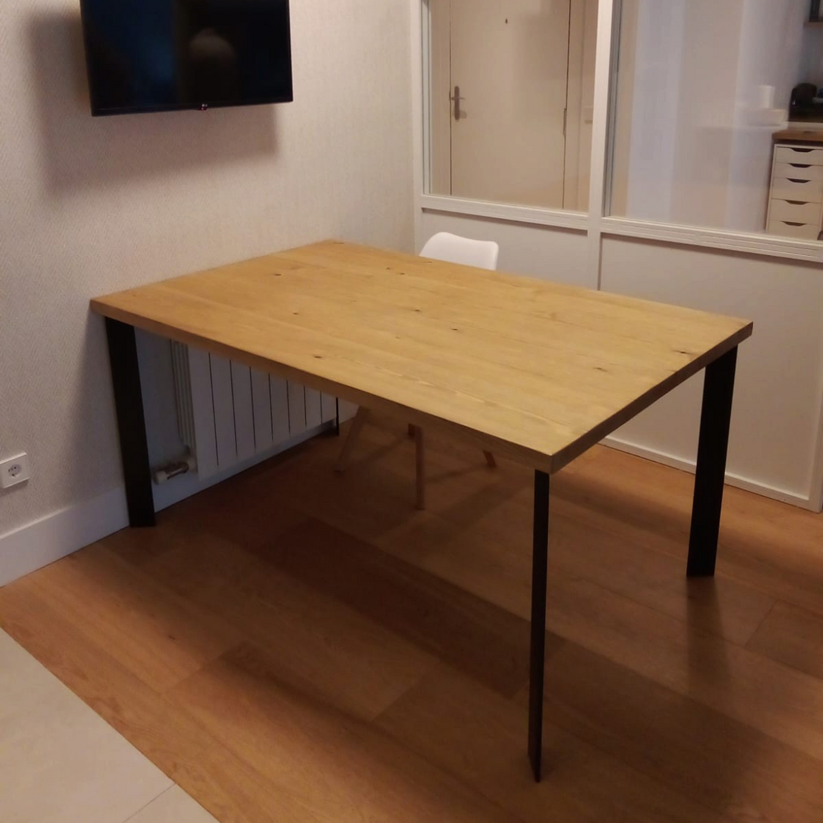 Vintage Industrial Kalumi dining table with a solid pine wood top in arena finish and black iron legs in a room