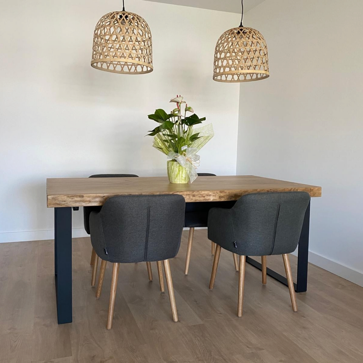 Vintage Industrial Sut dining table in honey-finished solid pine wood with black iron legs and four grey chairs.