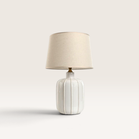 Vintage Industrial Lumi table lamp with a white ribbed ceramic base, brass accents, and a neutral fabric shade.