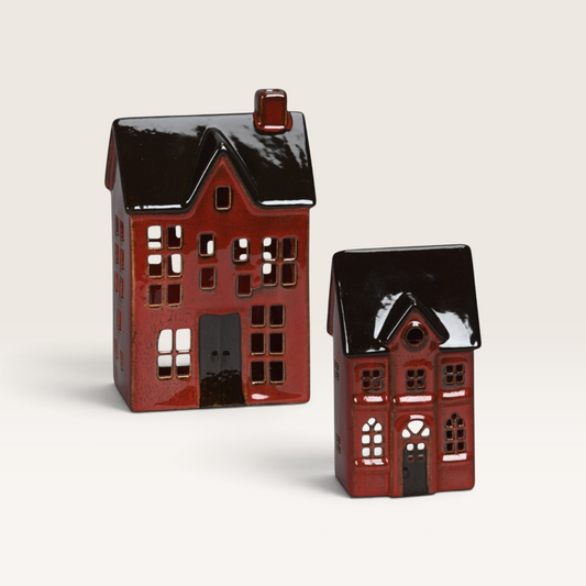 Vintage Industrial red porcelain house ornaments with glossy dark roofs and cut-out windows for holiday decor.